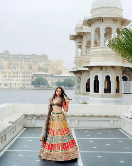 Photo of Bridal portrait in a multi coloured lehenga by Sabyasachi at a destination wedding venue