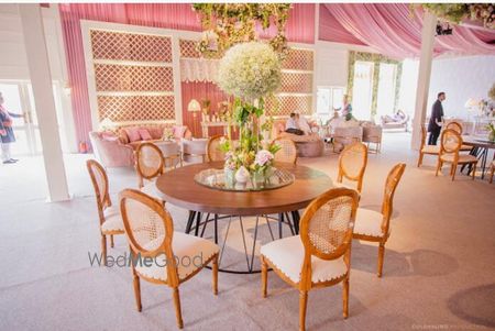 Photo of pretty round table setting with floral centrepiece