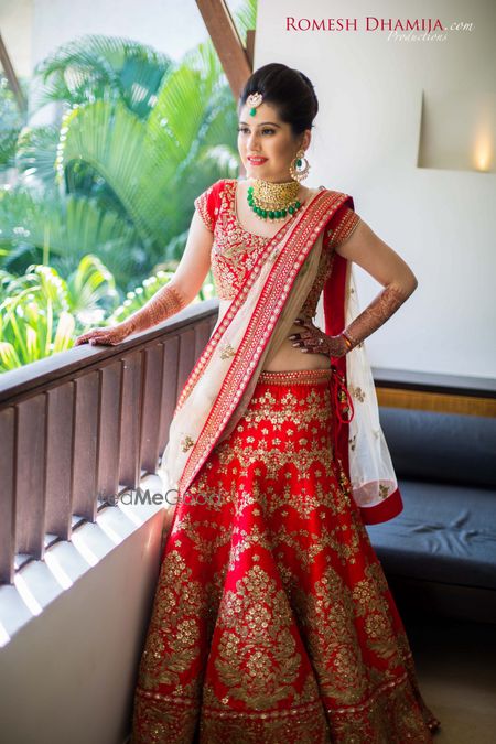 Photo of Red and white bridal lehenga with green jewellery