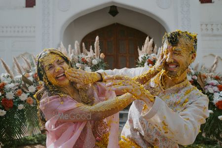 Photo of Fun haldi photo with the bride and groom smeared with haldi