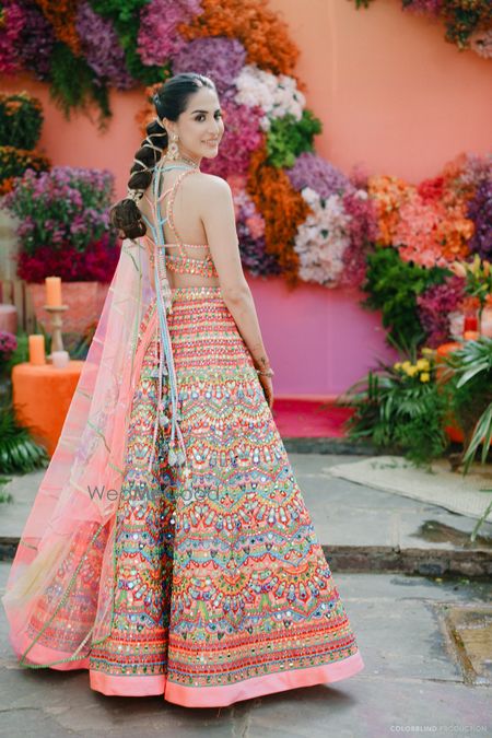 Photo of Bright and colourful mehendi decor and mehendi lehenga for this bride with a gota patti hair braid hairstyle