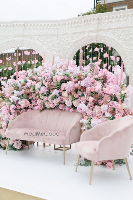 Photo of pink floral backdrop with pink seating