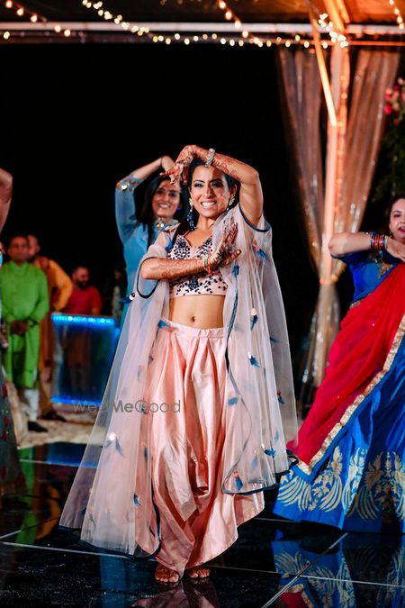 Photo of Dancing bride shot wearing a peach cape outfit