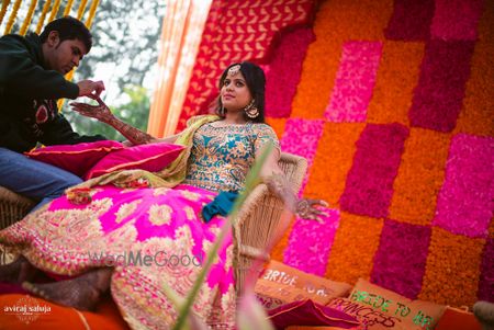 Photo of Bride putting mehendi in neon leheng