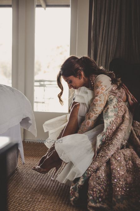 Photo of Getting ready photo of bride slipping her shoes on