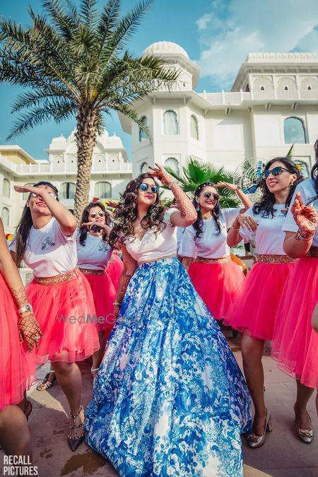 Photo of Bride with matching bridesmaids in red on mehendi