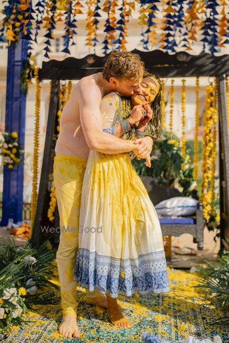 Photo of cute groom kissing bride shot on haldi