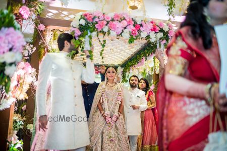 Photo of A bride in ivory lehenga enters under a phoolon ki chadar