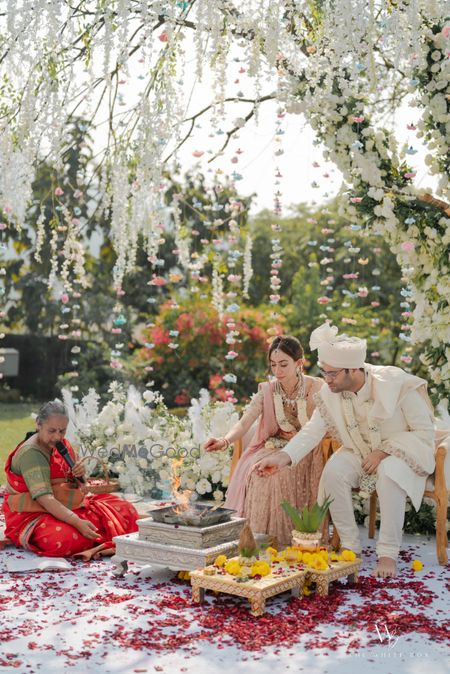 Photo of A gorgeous wedding shot with a female priestess doing the wedding in an outdoor setup and white florals