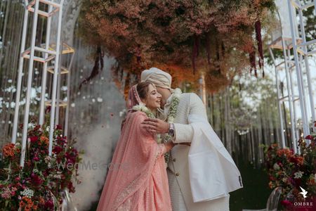 Photo of cute bride and groom hugging after jaimala photo