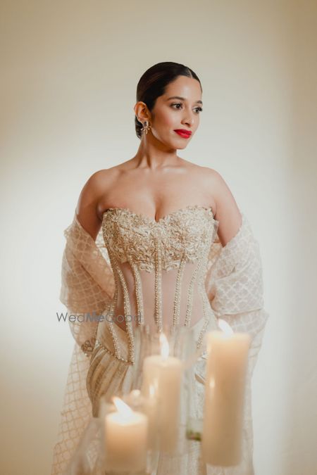 Photo of Glam bridal look in a sheer and strapless gown in beige and gold with a dupatta