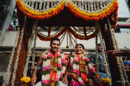 Photo of Couple portrait on a jhoola with genda phool decor