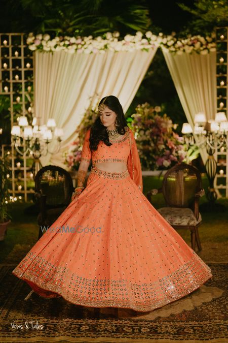 Photo of Stunning orange and peach lehenga shot as the bride twirles around!