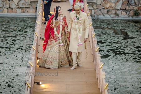 Photo of Bride and groom walking hand in hand.