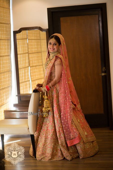 Photo of Coral pink bridal lehenga by Sabyasachi