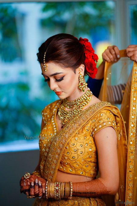 Photo of Bride with orange smokey eye and contrasting red bun