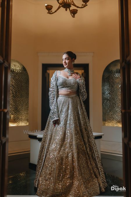 Photo of Statement shimmer lehenga in gold and silver with a floor length jacket and jade jewellery for the sangeet night