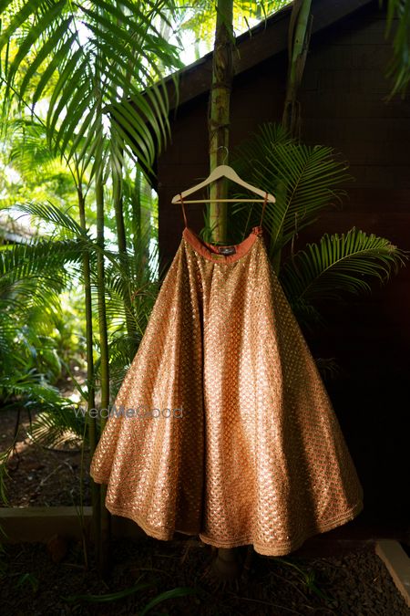 Photo of burnt orange sabyasachi lehenga on hanger