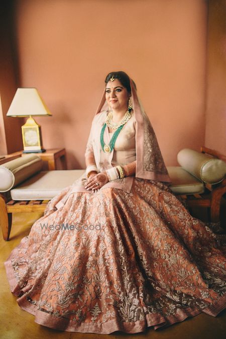 Photo of elegant pastel peach bridal lehenga with long top