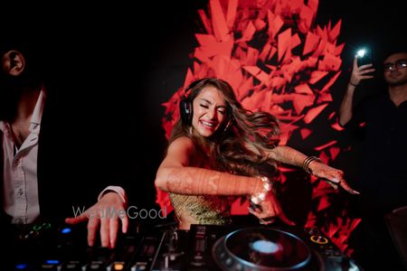 Photo of This funky bridal shot of the bride playing the DJ at her cocktail event