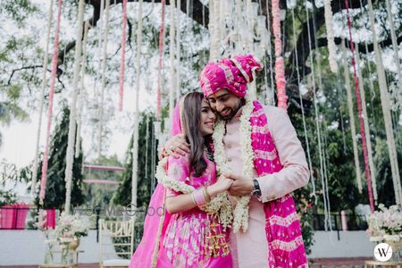 Photo of cute bride and groom home wedding photo wearing matching outfits with a pop of pink