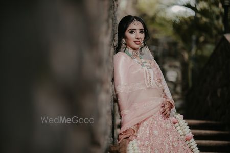 Photo of bridal portrait with floral kaleere and green jewellery with pastel lehenga