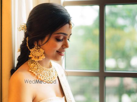 Photo of A bride flaunting her gold choker and waterfall earrings with multiple jhumkis