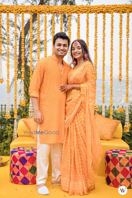 Photo of twinning bride and groom in yellow on haldi