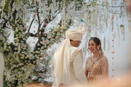 Photo of Candid capture of the bride and groom in pastel outfits for an outdoor wedding