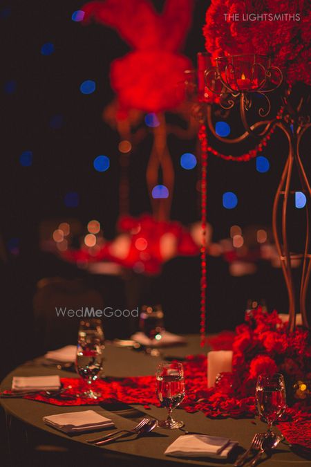 Photo of black and red table centerpieces for sangeet moulin rouge theme