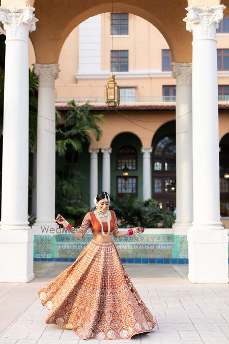 Photo of Twirling bride in burnt orange lehenga