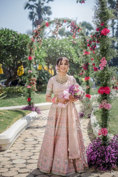 Photo of Bride dressed in a baby pink lehenga.