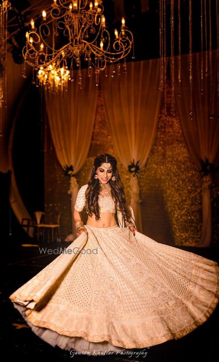 Photo of Twirling bride shot with Ivory and gold lehenga