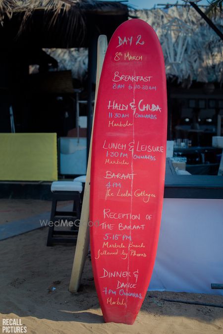 Photo of Beach theme mehendi decor idea with menu on surfboard