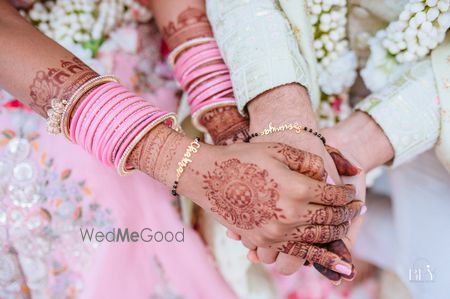 Photo of progressive couple hand shot with mangalsutra bracelet and their nameplates