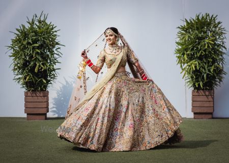 Photo of Gold bridal lehenga with colorful details