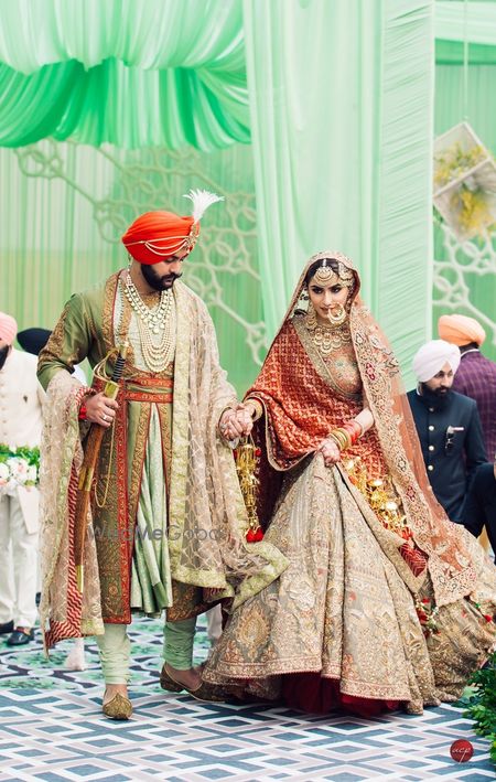 Photo of A groom helping a bride walk on their wedding day