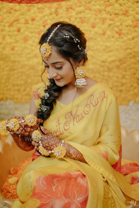 Photo of haldi bridal look with floral jewellery and side braid