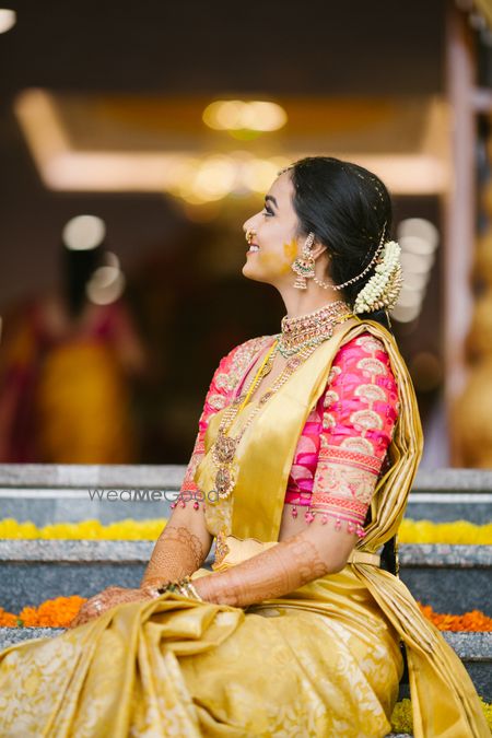 Photo of A happy bridal shot in yellow and gold saree.