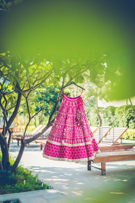 Photo of Bright pink and mint bridal lehenga on hanger