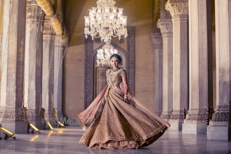 Photo of Bride twirling in gold bridal lehenga