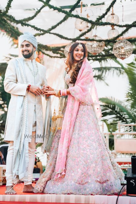 Photo of Bride and groom in pastel wedding outfits