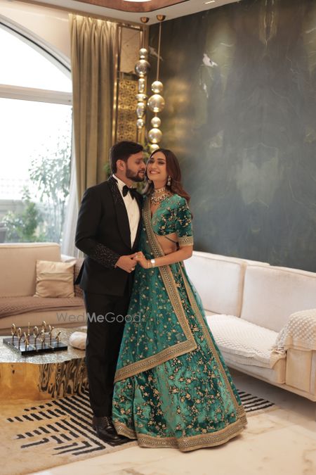 Photo of Cute couple photo with the groom in a tuxedo and bride in a teal blue velvet lehenga