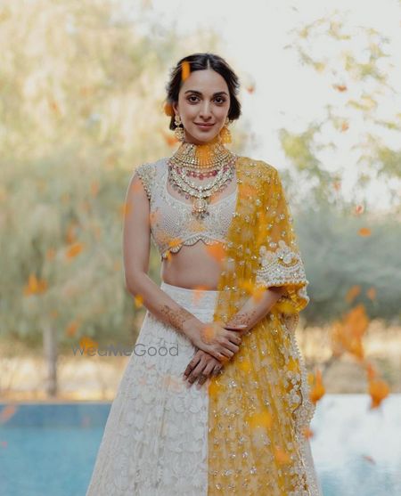 Photo of kiara advani on her mehendi in an ivory chikankari lehenga with a yellow dupatta