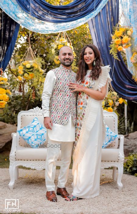 Photo of The couple on their engagement party with the bride in a white ruffle saree!