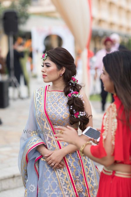 Photo of Mehendi hairstyle braid with flowers in pink and white