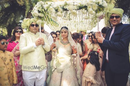 Photo of A gorgeous bridal entry with the bride under a white phoolon ki chaadar