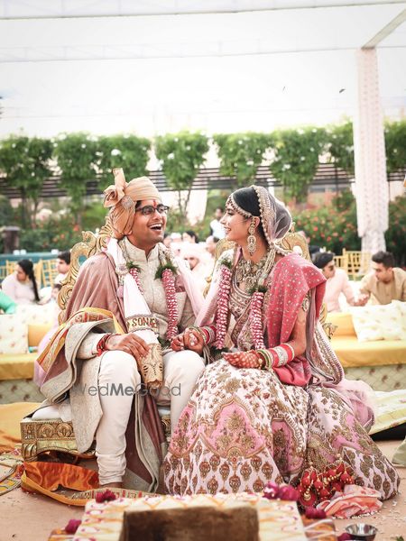 Photo of A bride and groom in color-coordinated pink outfits at their wedding