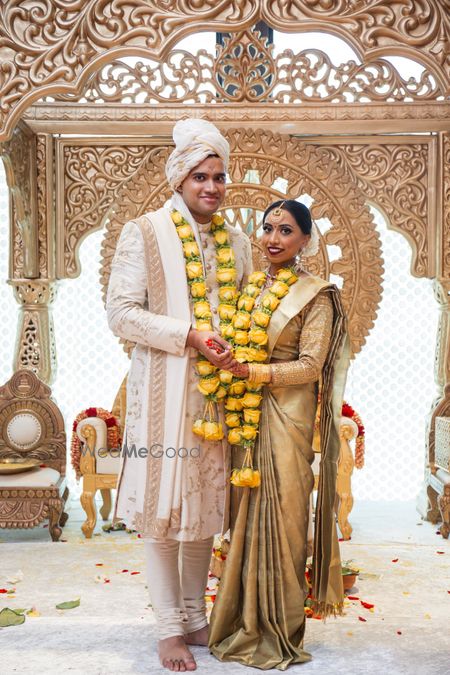 Photo of south indian couple shot with unique yellow jaimalas