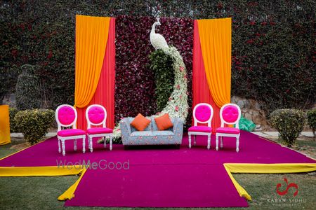 Photo of mehendi stage backdrop with peacock prop